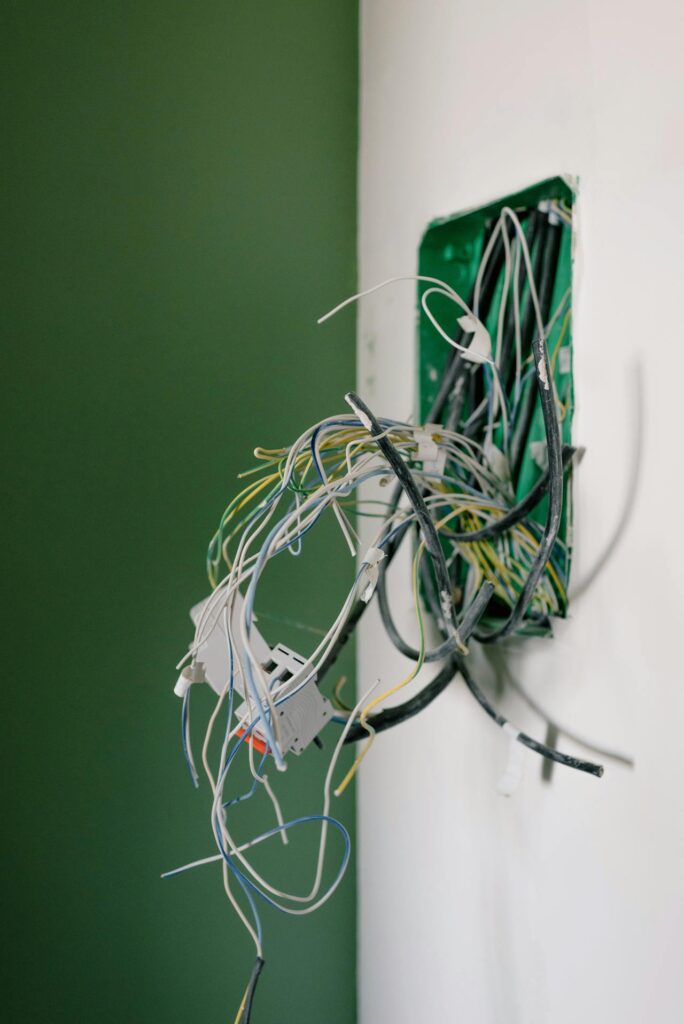 Mise en conformité électrique - Photo d'illustration représentant un point électrique avec arrivé de divers fils électriques dans un mur